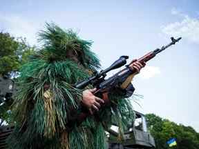 Un tireur d'élite ukrainien en tenue de camouflage attend sur la ligne de front non loin de la ville de Debaltseve, dans l'est de l'Ukraine, dans la région de Donetsk, le 25 août 2014.