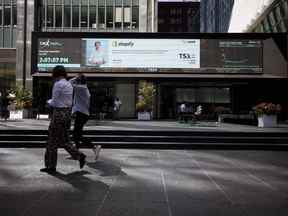 Les piétons passent devant la Bourse de Toronto dans le quartier financier de Toronto.