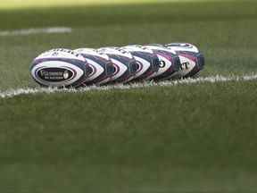 Ballons de rugby alignés sur le terrain.