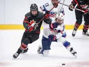 Jocelyne Larocque du Canada affronte Amanda Kessel et Hannah Bilka des États-Unis lors du match de hockey sur glace féminin du Championnat du monde de l'IIHF entre le Canada et les États-Unis à Herning, au Danemark, le mardi 30 août 2022.