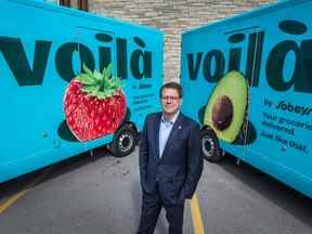 Michael Medline, directeur général de mpire Co., pose devant des camions de livraison Voilà.