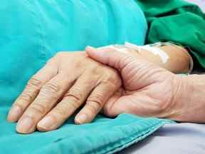 Médecin oncologue tenant la main du patient à l'hôpital.  Montrer tout l'amour, l'empathie, l'aide et l'encouragement.  Il a une maladie cancéreuse en phase terminale.  Soins de santé en fin de vie et concept de soins palliatifs
