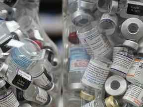 Des bocaux remplis de flacons vides de vaccin COVID-19 sont exposés à la pharmacie Junction Chemist pendant la pandémie de COVID-19 à Toronto le mercredi 6 avril 2022.