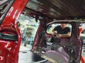 Un travailleur installe des pièces sur la chaîne de production de l'usine Chrysler, à Windsor, en Ontario, le 18 janvier 2011.