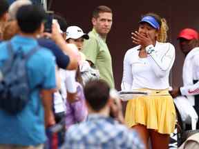 Naomi Osaka, du Japon, essuie une larme en donnant sa raquette à un fan après s'être retirée tôt de son match contre Kaia Kanepi, d'Estonie, lors de l'Open Banque Nationale, qui fait partie de la tournée Hologic WTA, au stade Sobeys le 9 août 2022 à Toronto.