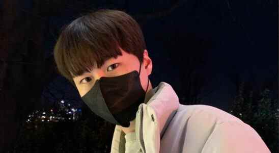 Overwatch pro Myunbong dons a black face mask and an off-white puffer jacket, pictured from the shoulders up.