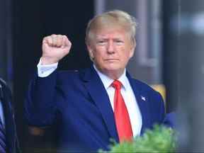 L'ancien président américain Donald Trump lève le poing en marchant vers un véhicule à l'extérieur de la Trump Tower à New York le 10 août 2022.