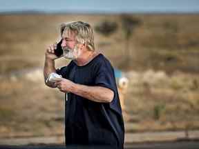 Alec Baldwin parle au téléphone sur le parking devant le bureau du shérif du comté de Santa Fe à Santa Fe, NM, après avoir été interrogé sur une fusillade sur le tournage du film "Rouiller" à la périphérie de Santa Fe, le jeudi 21 octobre 2021.