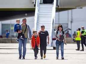Une famille de réfugiés ukrainiens arrive à l'aéroport international Pearson de Toronto dans un avion en provenance de Pologne, le dimanche 15 mai 2022.