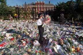 Une policière britannique récupère certains des bouquets de fleurs laissés devant le palais de Kensington à Londres, l'ancienne résidence de la princesse de Galles.