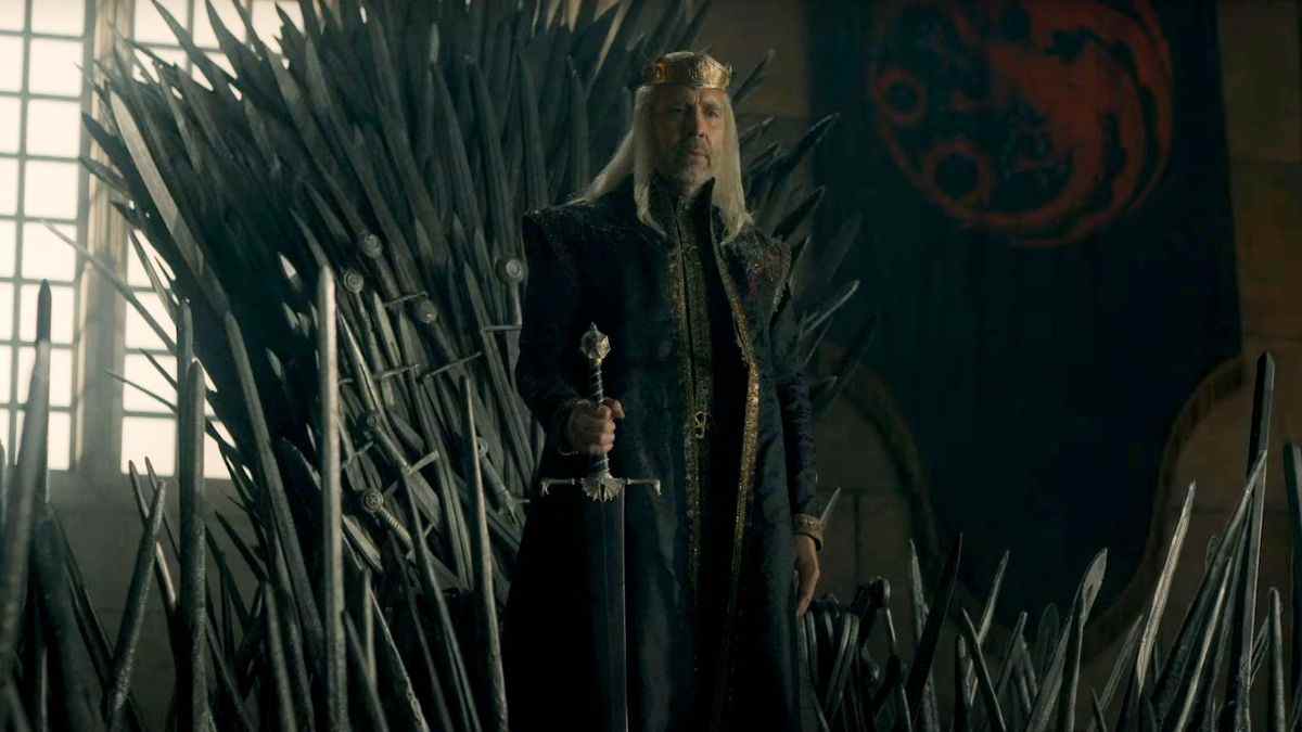 Viserys se tient devant le trône de fer tenant la poignée de son épée dans House of the Dragon.