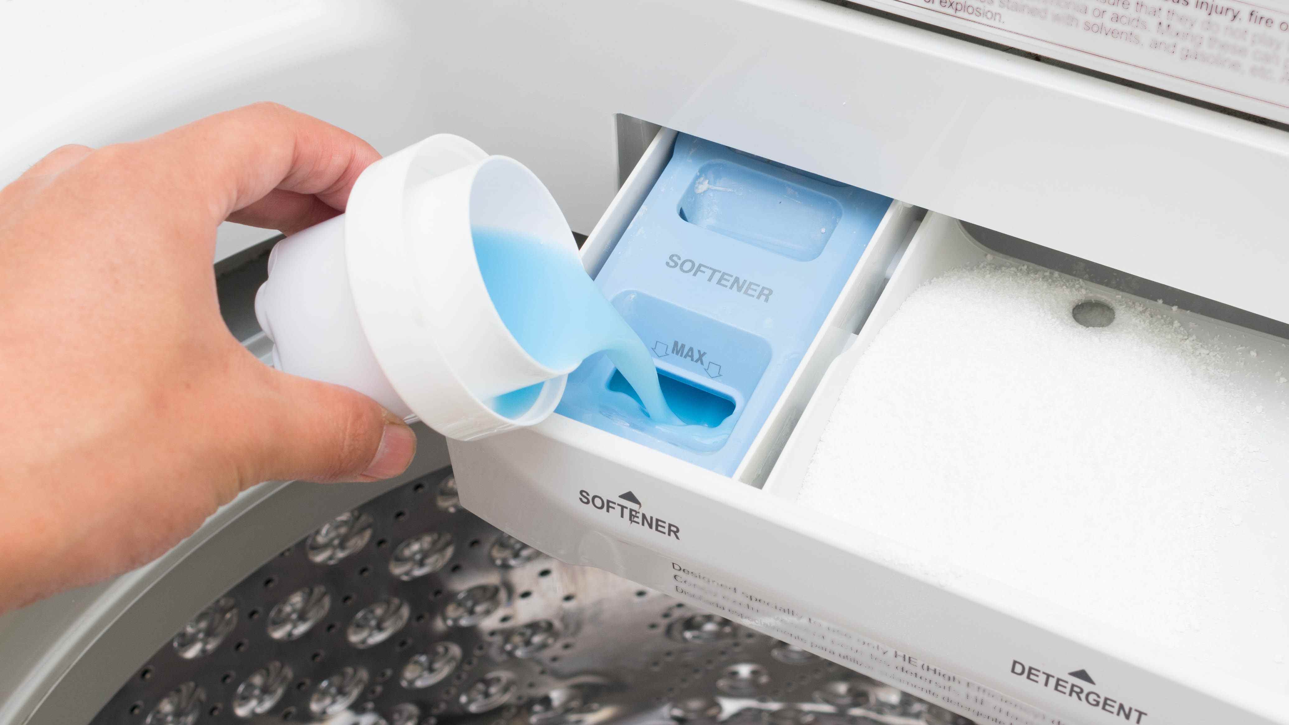L'assouplissant est ajouté à un tiroir à lessive dans une machine à laver