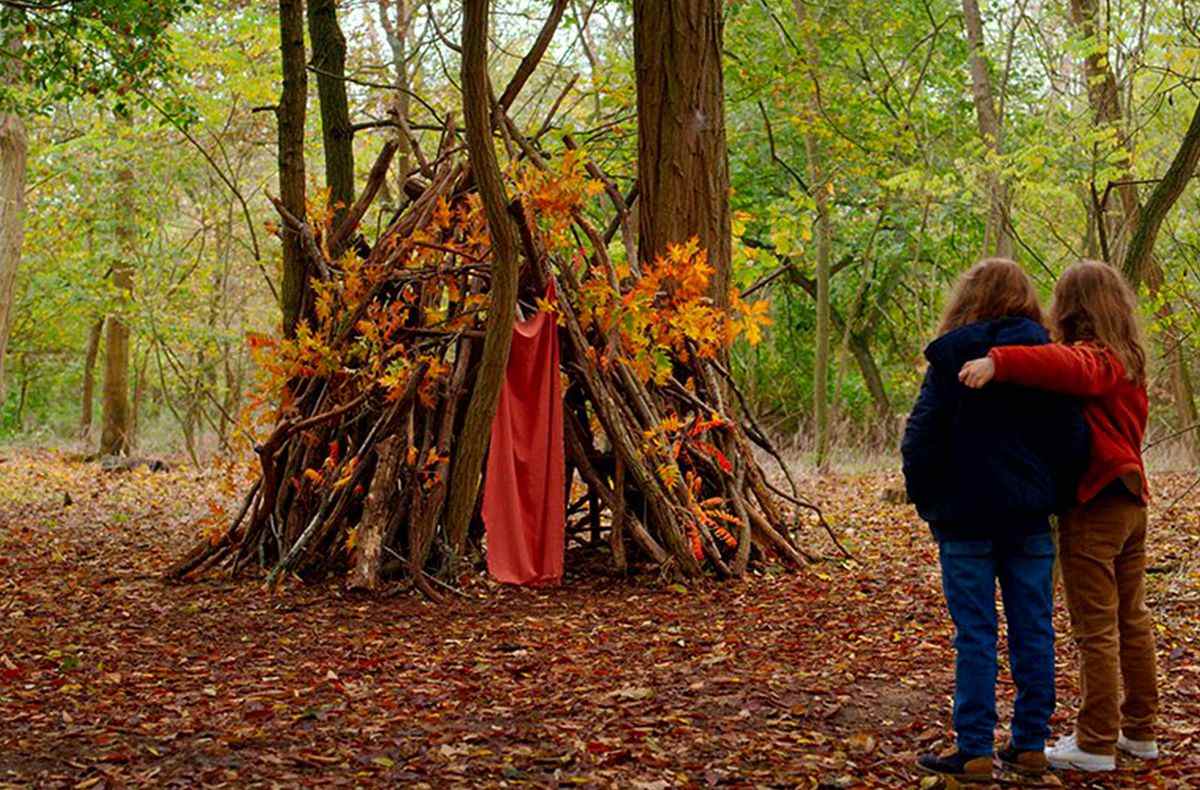 Deux jeunes filles enlacées contemplent leur fort bâton dans la forêt à Petite Maman