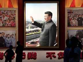 Les gens se tiennent devant des images du président chinois Xi Jinping au Musée du Parti communiste chinois à Pékin.