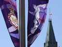 Le drapeau de la tour de la Paix flotte en berne derrière les bannières de la reine Elizabeth célébrant le jubilé de platine, à Ottawa, le jeudi 8 septembre 2022. 