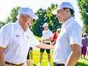 L'ancien capitaine des Canadiens et membre du Temple de la renommée Yvan Cournoyer s'entretient avec le nouveau capitaine de l'équipe Nick Suzuki lors du tournoi de golf de l'équipe lundi à Laval-sur-le-Lac.