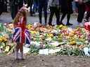 Ann Doran, six ans, se tient près des hommages floraux laissés à Green Park, après la mort de la reine Elizabeth de Grande-Bretagne, à Londres le 15 septembre 2022. 