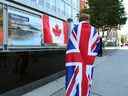 La pleureuse Eissa Saddozai drapée d'un drapeau Union Jack se tient devant le haut-commissariat britannique à Ottawa après le décès de la reine Elizabeth II le 8 septembre 2022,