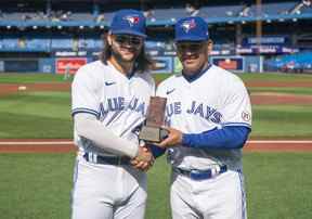 Bo Bichette des Blue Jays de Toronto pose après avoir été nommé nominé des Blue Jays pour le prix Roberto Clemente avec l'entraîneur du troisième but Luis Rivera avant d'affronter les Rays de Tampa Bay lors de leur match de la MLB au Rogers Centre le 15 septembre 2022 à Toronto.