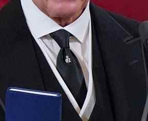 Gros plan d'une épingle à cravate en argent portée par le roi Charles III à la cathédrale Saint-James de Londres le dimanche 11 septembre 2022. L'épingle représente le chiffre royal du grand-père du roi, George VI.