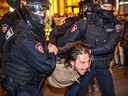 Des policiers russes arrêtent un homme à la suite d'appels à protester contre la mobilisation partielle annoncée par le président russe, à Moscou, le 21 septembre 2022.