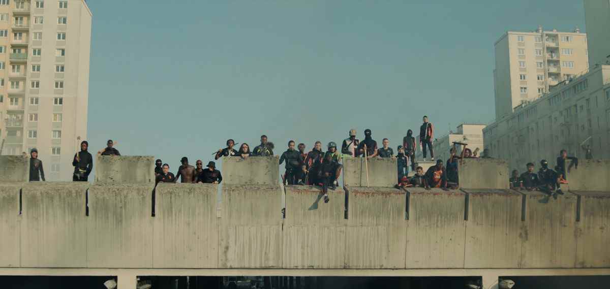 Un grand groupe de manifestants se tient au sommet d'un bâtiment regardant vers le bas à Athéna
