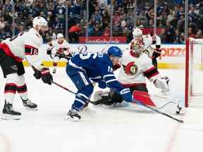 L'ailier des Maple Leafs Mitchell Marner tente de contrôler la rondelle devant le gardien des Sénateurs Cam Talbot en première période.