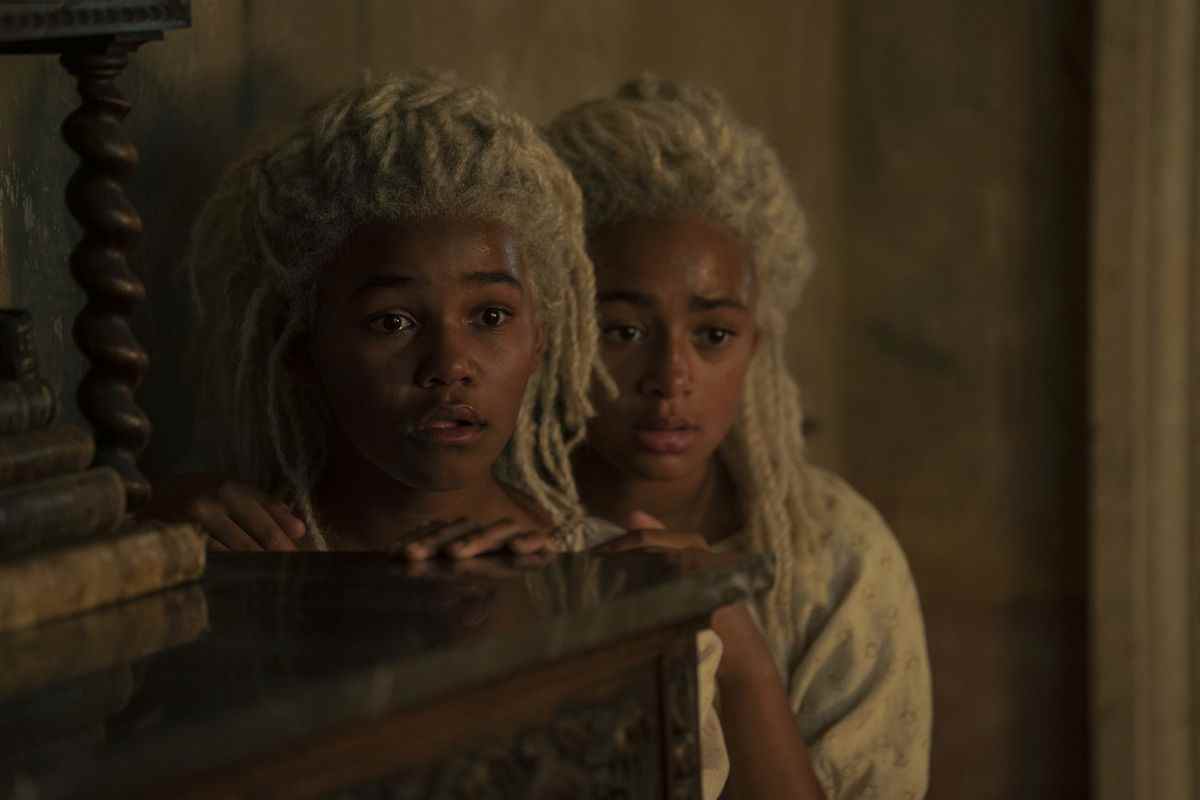 Shani Smethhurst et Eva Ossei-Gerning de House of the Dragon de HBO dans le rôle de Baela Targaryen et Rhaena Targaryen.  Ils ont des locs lumineux et regardent derrière une commode.