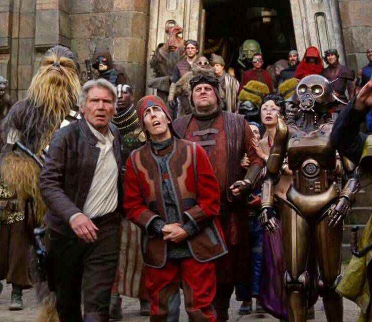 Un groupe de personnages de Star Wars, dont Han Solo, Chewbacca et le droïde ME-8D9, lève les yeux vers le ciel à l'extérieur du château de Maz Katana.