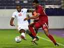 L'attaquant canadien David Hoilett (G) et le défenseur qatarien Homam Ahmed se disputent le ballon lors du match de football amical entre le Qatar et le Canada à Vienne le 23 septembre 2022.  