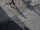 L'ombre d'un banlieusard est projetée sur le trottoir du quartier financier de Toronto.