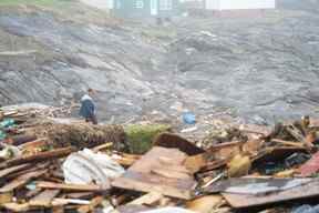 Une personne fouille le littoral à la suite de la tempête post-tropicale Fiona à Port Aux Basques, T.-N.-L., le 27 septembre 2022.