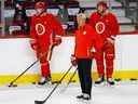 Elias Lindholm, à gauche, avec l'entraîneur-chef des Flames de Calgary Darryl Sutter et Jonathan Huberdeau lors du camp d'entraînement de jeudi.