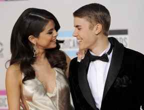 Dans cette photo d'archive du 20 novembre 2011, Selena Gomez, à gauche, et Justin Bieber arrivent à la 39e édition des American Music Awards à Los Angeles.
