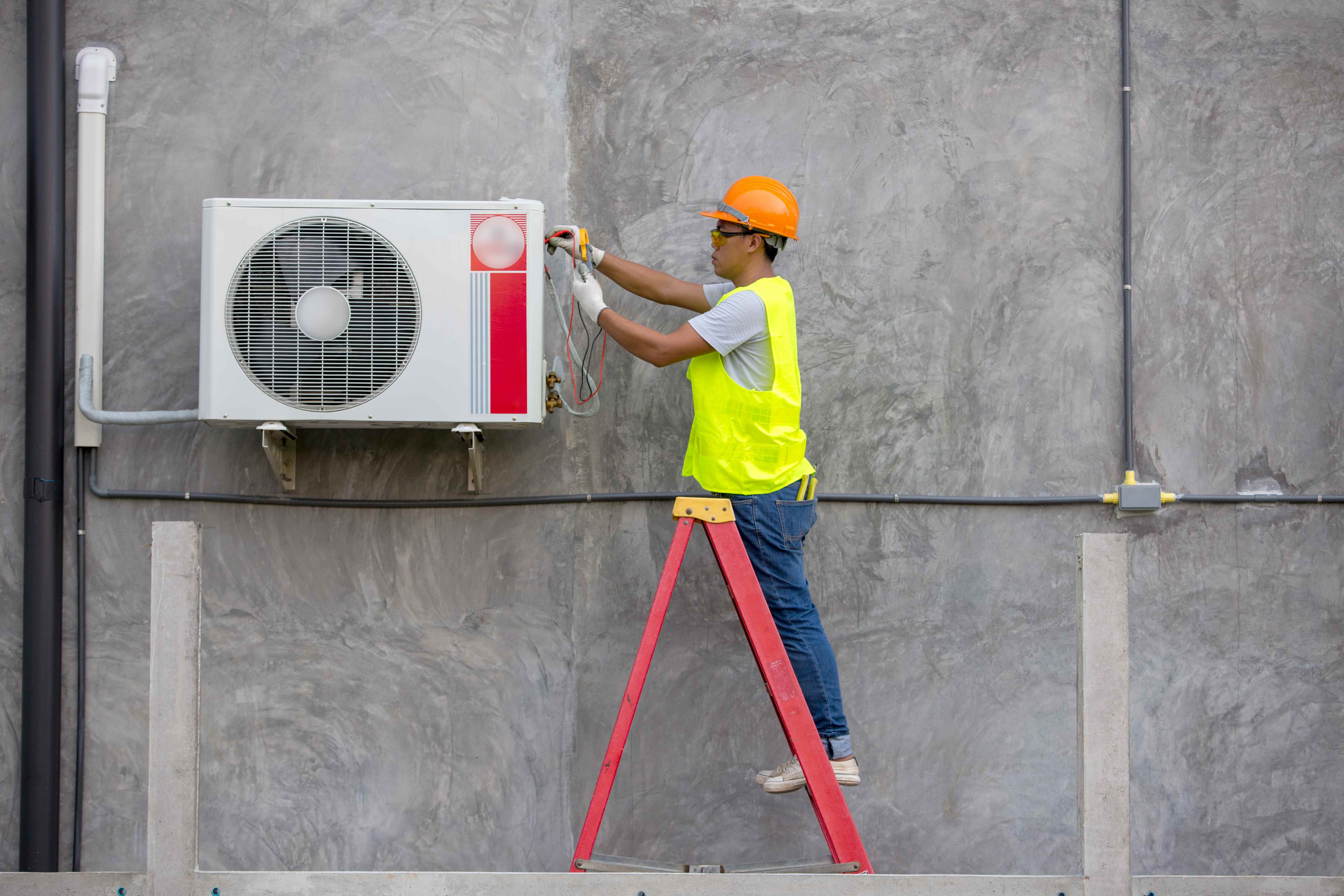 Image d'un service de technicien en climatisation vérifiant le climatiseur d'un bâtiment.