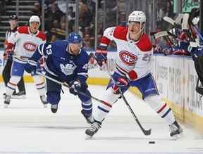 Juraj Slafkovsky des Canadiens de Montréal gère la rondelle contre Kyle Clifford des Maple Leafs de Toronto lors d'un match préparatoire de la LNH au Scotiabank Arena de Toronto le mercredi 28 septembre 2022.