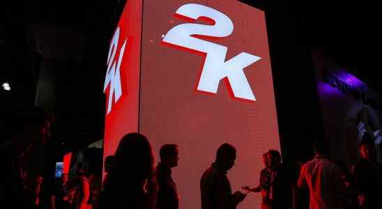 Attendees walk past signage for 2K Games Inc. during the E3 Electronic Entertainment Expo in Los Angeles, California, U.S., on Tuesday, June 10, 2014. E3, a trade show for computer and video games, draws professionals to experience the future of interactive entertainment as well as to see new technologies and never-before-seen products.