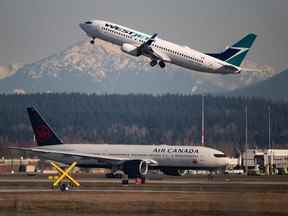 Un vol d'Air Canada au départ de Toronto, en bas, roule vers une piste alors qu'un vol Westjet à destination de Palm Springs décolle à l'aéroport international de Vancouver le vendredi 20 mars 2020.