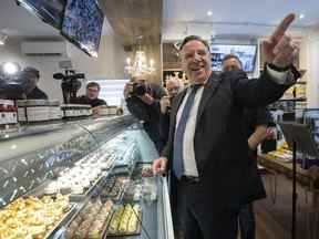 Le premier ministre du Québec, François Legault, sourit en visitant un magasin de gâteaux au fromage le mardi 17 mai 2022 à Laval, au Québec.