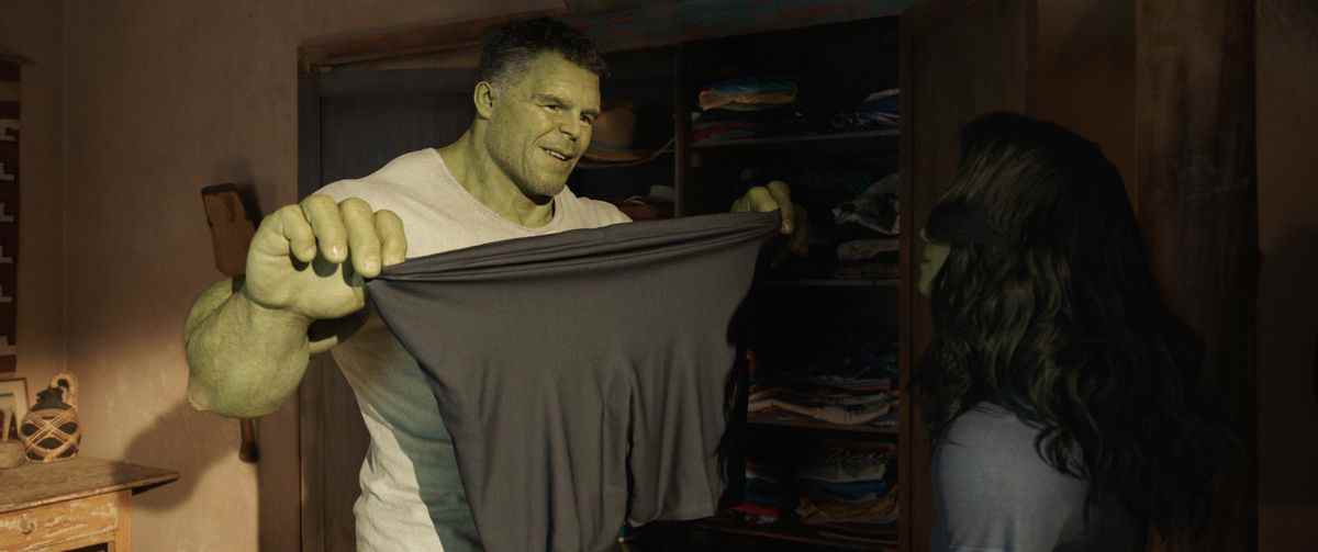 Bruce Banner dans le rôle de Smart Hulk tenant un short en spandex et l'étirant devant Jen, qui est dans le personnage de She-Hulk