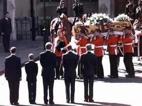 Le prince Charles, le prince Harry, le comte Spencer, le prince William et le duc d'Édimbourg de Grande-Bretagne regardent le cercueil portant le corps de Diana, princesse de Galles, être emmené à l'abbaye de Westminster pour ses funérailles à Londres le 6 septembre 1997.