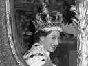 La reine Elizabeth II donne un large sourire à la foule depuis son chariot alors qu'elle quitte l'abbaye de Westminster, à Londres, après son couronnement.