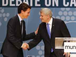 Le chef conservateur Stephen Harper, à droite, et le chef libéral Justin Trudeau se serrent la main après avoir participé au débat Munk sur la politique étrangère du Canada à Toronto, le lundi 28 septembre 2015.