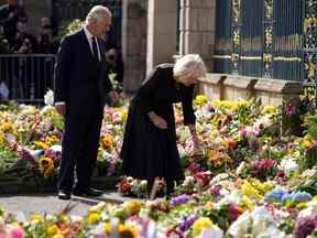 Le roi britannique Charles III (à gauche) et la britannique Camilla, reine consort (à droite) voient les hommages floraux laissés à l'extérieur du château de Hillsborough à Belfast le mardi 13 septembre 2022, lors de sa visite en Irlande du Nord.