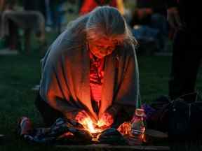 Une femme se prépare pour la cérémonie du lever du soleil, à laquelle assiste le premier ministre Justin Trudeau pour marquer la Journée nationale pour la vérité et la réconciliation, en l'honneur des enfants perdus et des survivants des pensionnats autochtones, à la centrale électrique de Niagara Parks à Niagara Falls, en Ontario, le 30 septembre 2022.