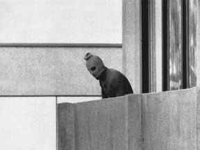 Un membre du groupe commando arabe qui a saisi des membres de l'équipe olympique israélienne dans leurs quartiers au village olympique apparaissant avec une cagoule sur son visage se tient sur le balcon de l'immeuble où les commandos ont retenu en otage des membres de l'équipe israélienne à Munich le sept. 5, 1972.