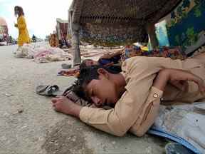 Sur cette photo prise le 2 septembre 2022, des enfants déplacés internes touchés par les inondations dorment sous un charpai alors qu'ils se réfugient dans le district de Bolan, dans la province du Balouchistan.