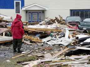 Un Ranger des Forces canadiennes examine les dommages causés à une maison à Port aux Basques, T.-N.-L., le lundi 26 septembre 2022.