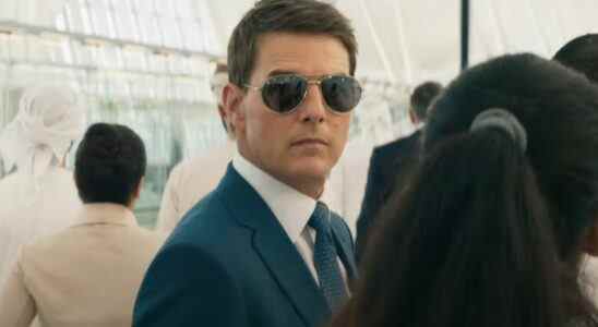 Tom Cruise stands in a crowd wearing sunglasses in Mission: Impossible - Dead Reckoning Part One.