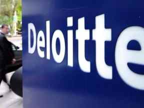 Un piéton passe devant une enseigne Deloitte au centre-ville d'Ottawa le mardi 20 septembre 2011. Un marché du travail serré et des économies élevées pendant la pandémie amortiront l'impact d'une récession sur les Canadiens, selon un nouveau rapport de Deloitte.